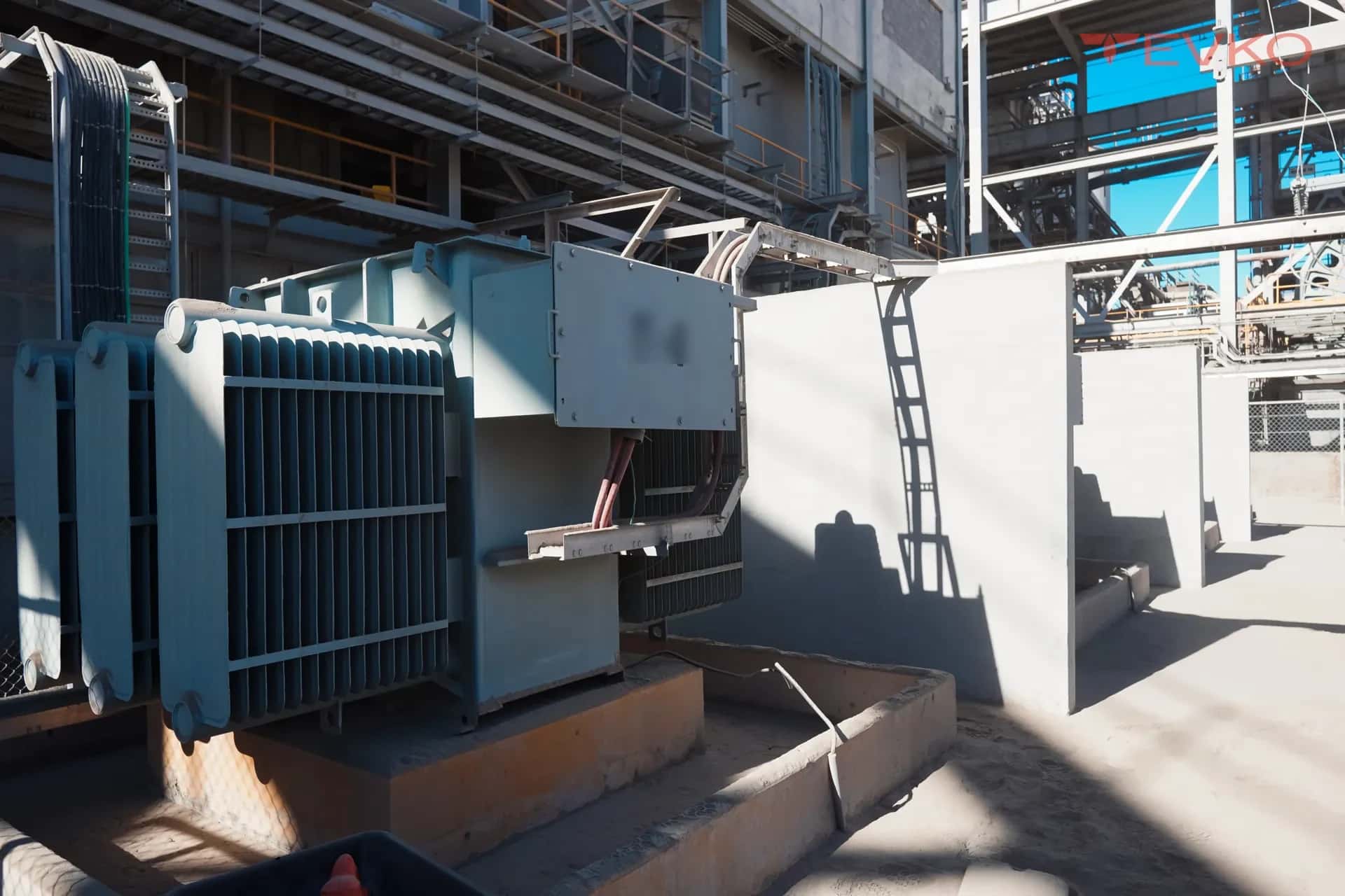 Transformador con radiadores sobre base de concreto en una planta industrial
