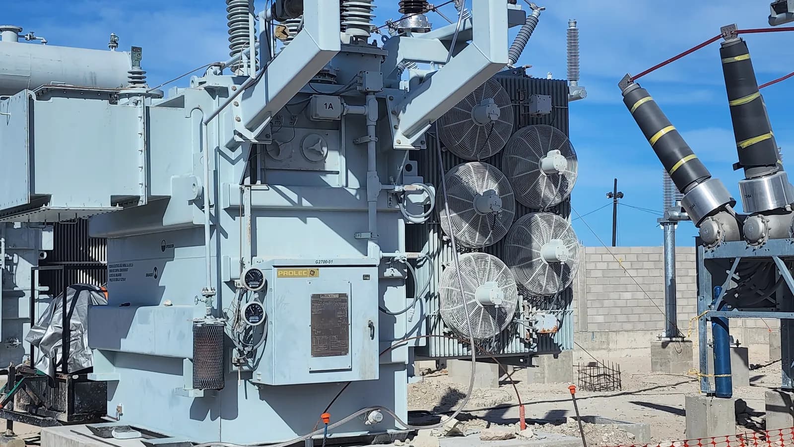 Costado de un transformador de potencia con su banco de radiadores, los ventiladores de enfriamiento y el gabinete de control