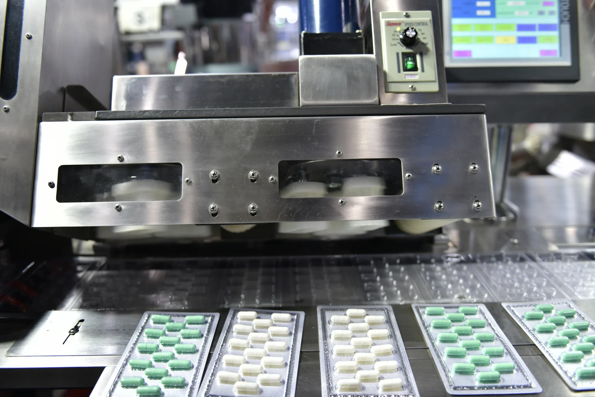 Máquina de blísteres formando los alvéolos y sellando comprimidos en una línea de acondicionamiento.